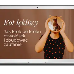 Na ekranie laptopa tekst "Kot lękliwy. Jak krok po kroku oswoić lęk i zbudować zaufanie." nad zdjęciem kota w okrągłym lustrze.